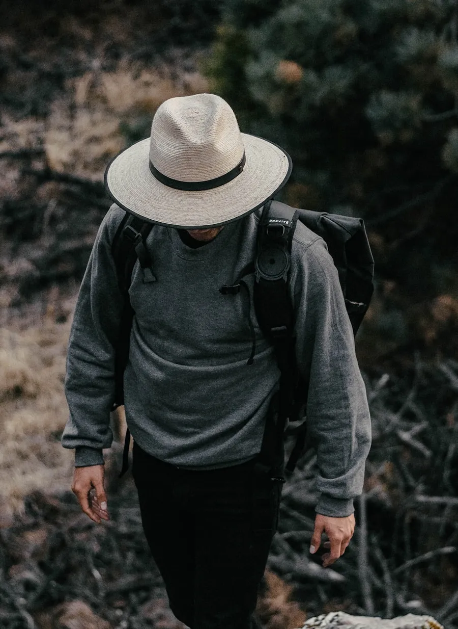 Hiker wearing layered outdoor clothing on a trail