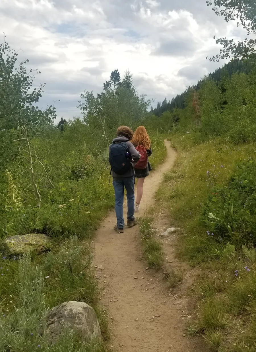 Hiker outdoors wearing trail clothing while considering jeans for hiking