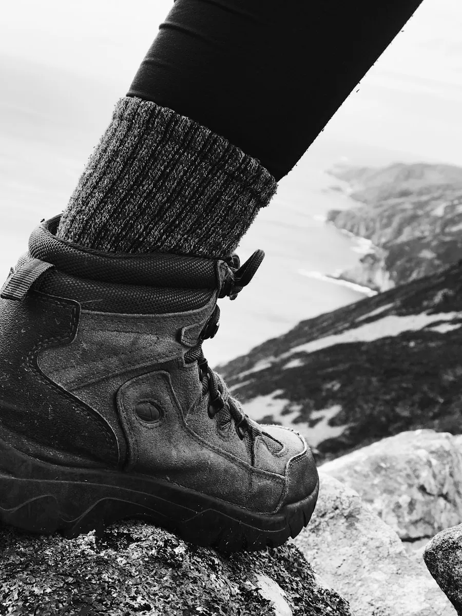 Are High Top Hiking Boots Better for Support and Stability? Hiker testing the fit and support of hiking boots outdoors