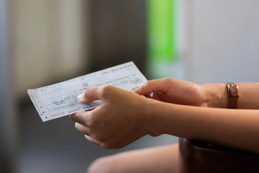 Airline check-in agent reviewing a passenger's identification and ticket at the counter