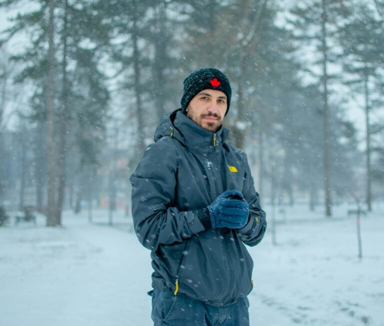 Best Heated Jackets of 2026 Person wearing an insulated winter jacket in a snowy forest